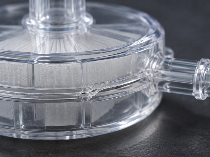 illustration of a local weld seam defect on a clear plastic filter housing